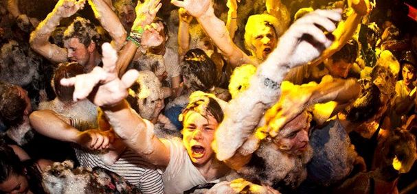 people at a nightclub with their arms in the air